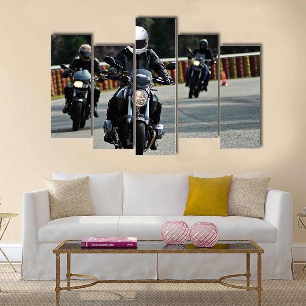 Biker on road with helmet and wet asphalt Multi panel canvas wall art
