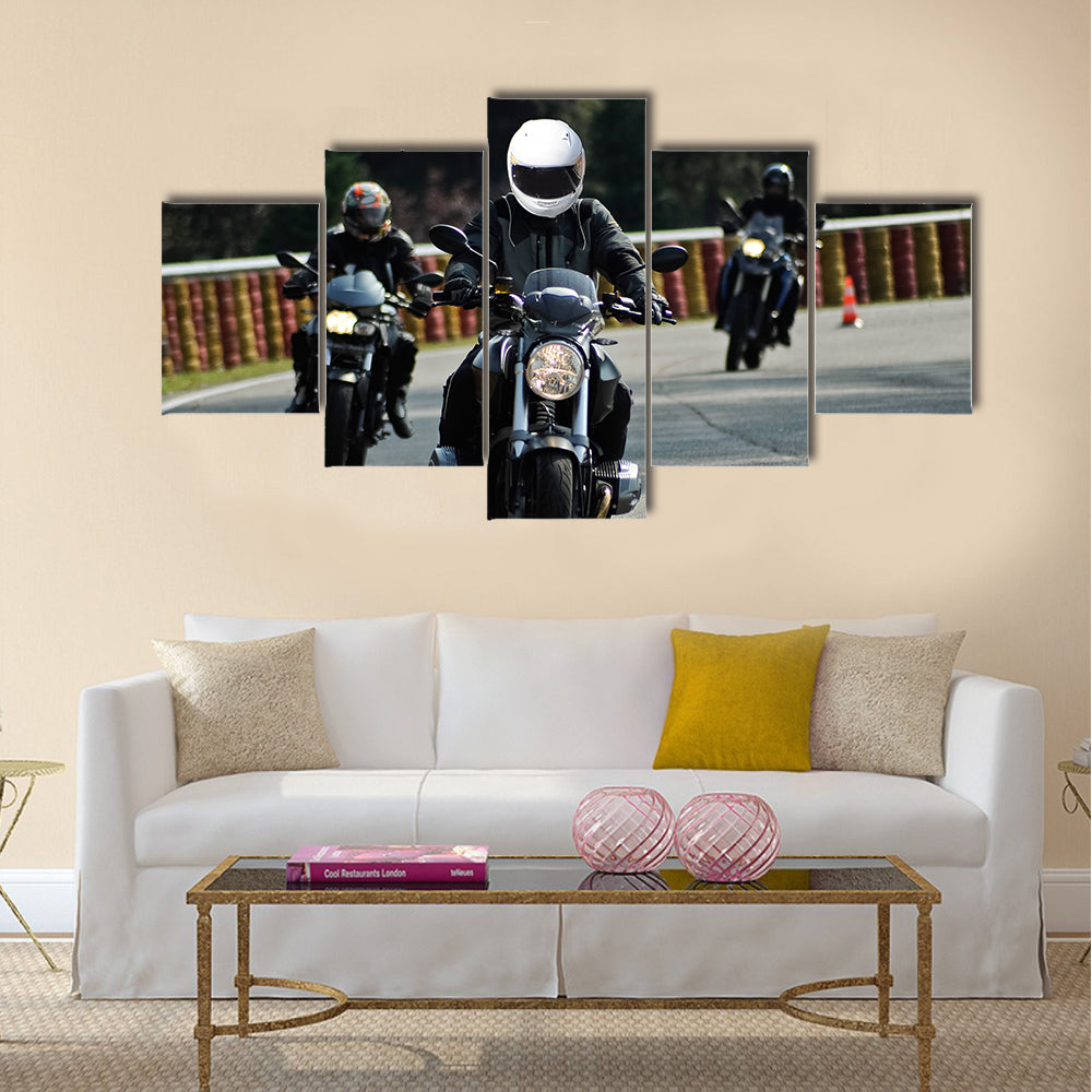 Biker on road with helmet and wet asphalt Multi panel canvas wall art