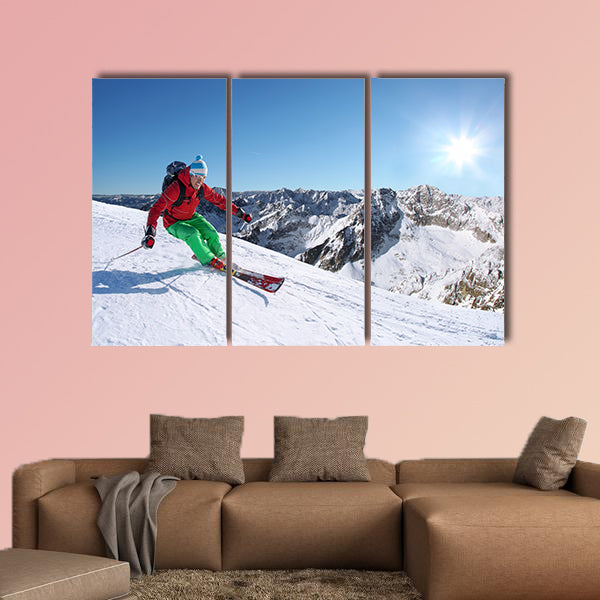 Skier skiing downhill in high mountains against sunset Multi panel canvas wall art