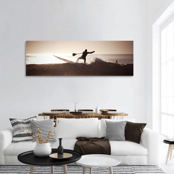 Silhouette of a man paddle boarding panoramic canvas wall art