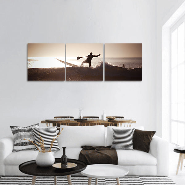 Silhouette of a man paddle boarding panoramic canvas wall art
