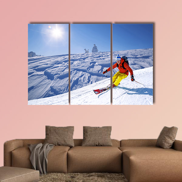 Skier skiing downhill in high mountains Multi panel canvas wall art
