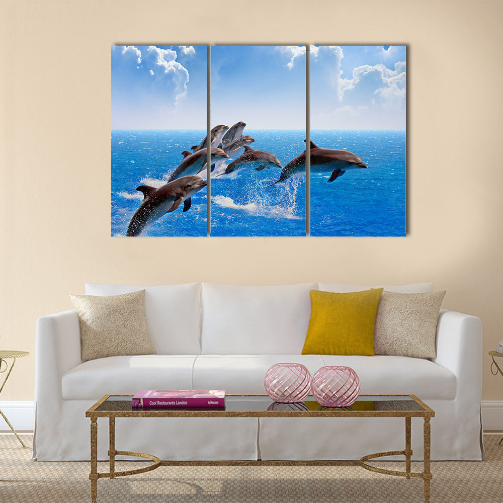 Jumping dolphins, blue sea and sky, white clouds Multi Panel Canvas Wall Art