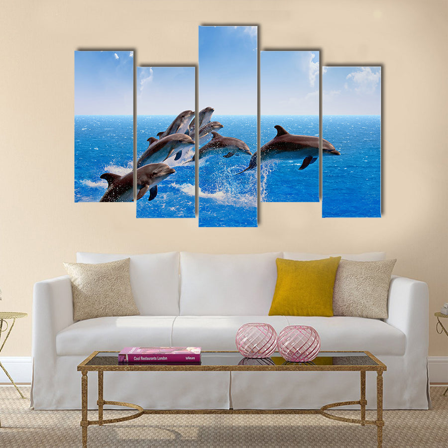 Jumping dolphins, blue sea and sky, white clouds Multi Panel Canvas Wall Art