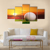 Golf ball on the lawn in sunset lights Multi Panel Canvas Wall Art