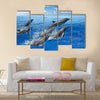 Graceful Jumping dolphins, blue sea and sky, white clouds Multi Panel Canvas Wall Art