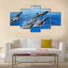 Graceful Jumping dolphins, blue sea and sky, white clouds Multi Panel Canvas Wall Art