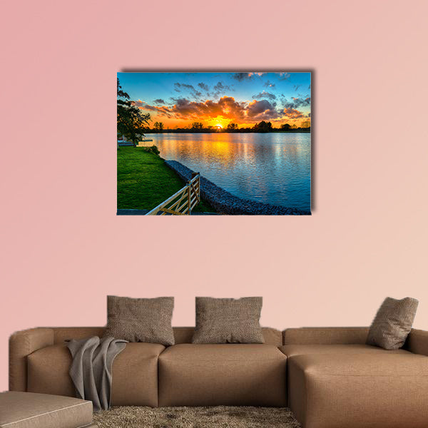 Sunset over a lake from land in the winter multi panel canvas wall art