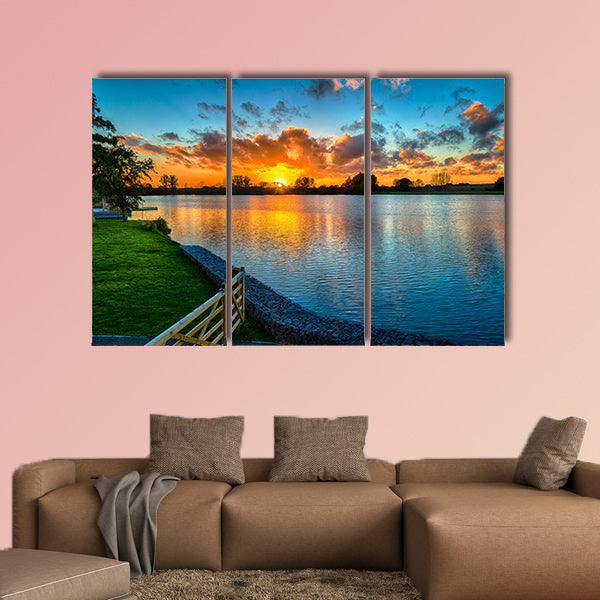 Sunset over a lake from land in the winter multi panel canvas wall art
