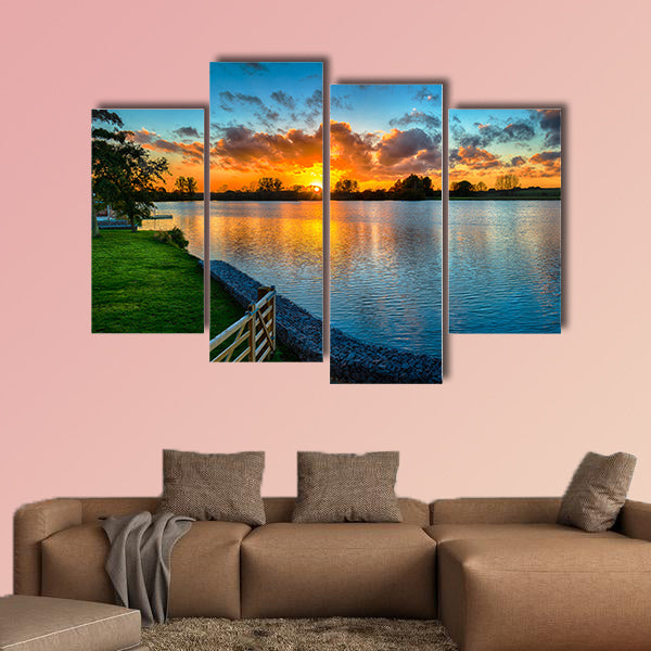Sunset over a lake from land in the winter multi panel canvas wall art