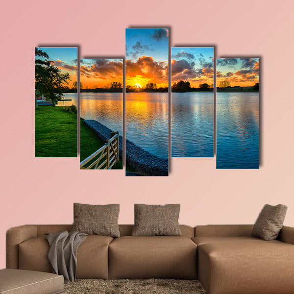 Sunset over a lake from land in the winter multi panel canvas wall art