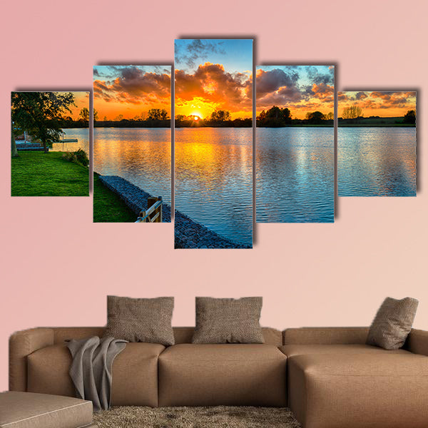 Sunset over a lake from land in the winter multi panel canvas wall art