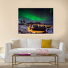 A man looking at the Northern lights over Reine, Lofoten islands, Norway Multi panel canvas wall art