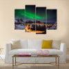 A man looking at the Northern lights over Reine, Lofoten islands, Norway Multi panel canvas wall art