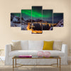 A man looking at the Northern lights over Reine, Lofoten islands, Norway Multi panel canvas wall art