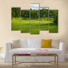 A golf green with bunkers with backdrop of trees Multi Panel Canvas Wall Art