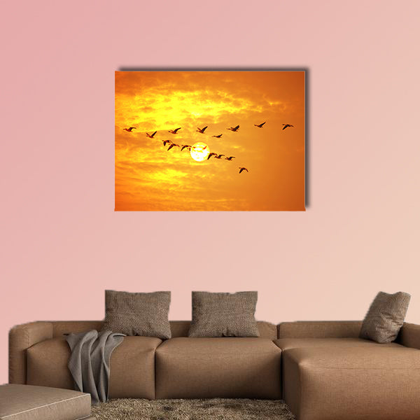 Flying birds against orange sunset Multi panel canvas wall art