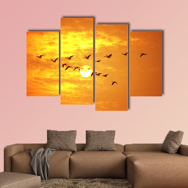 Flying birds against orange sunset Multi panel canvas wall art