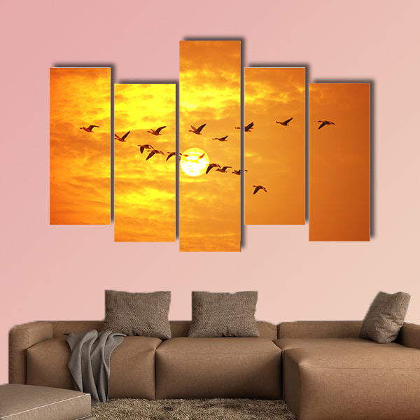 Flying birds against orange sunset Multi panel canvas wall art