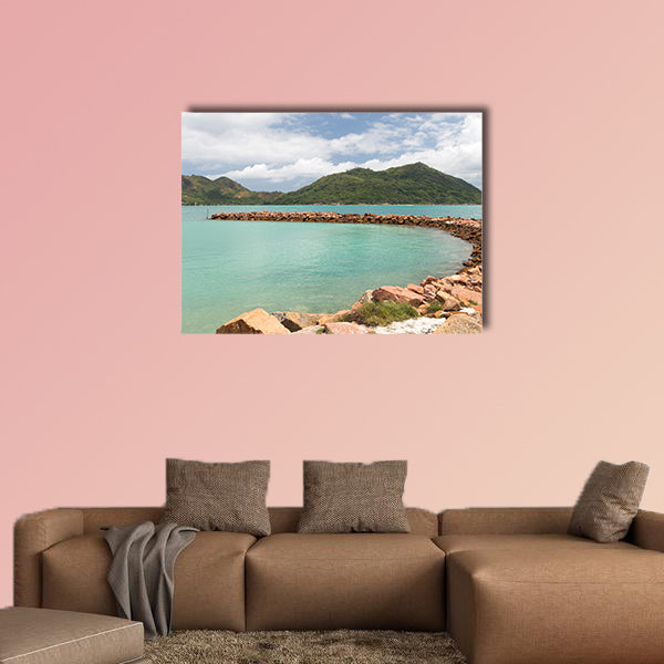 Breakwater of orange stones and the beautiful green mountains wall art