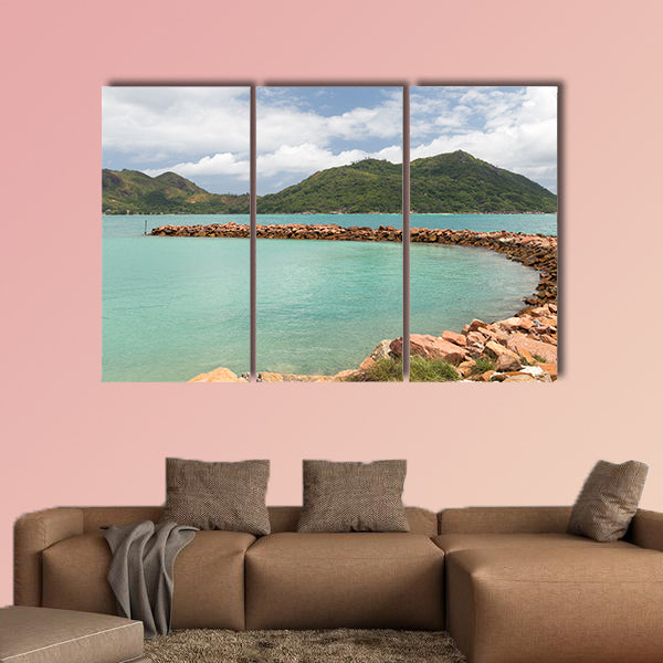Breakwater of orange stones and the beautiful green mountains wall art
