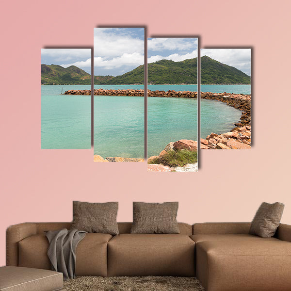 Breakwater of orange stones and the beautiful green mountains wall art