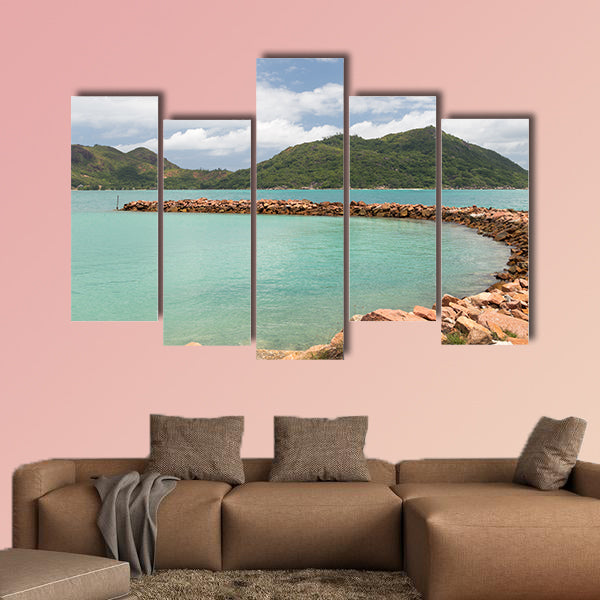 Breakwater of orange stones and the beautiful green mountains wall art