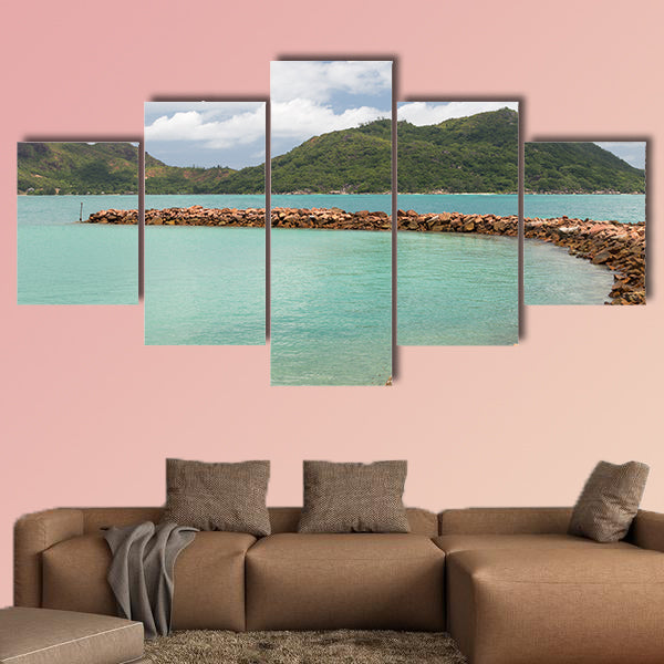 Breakwater of orange stones and the beautiful green mountains wall art
