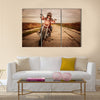 Biker girl in a leather jacket and helmet on a motorcycle Multi panel canvas wall art