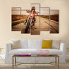 Biker girl in a leather jacket and helmet on a motorcycle Multi panel canvas wall art