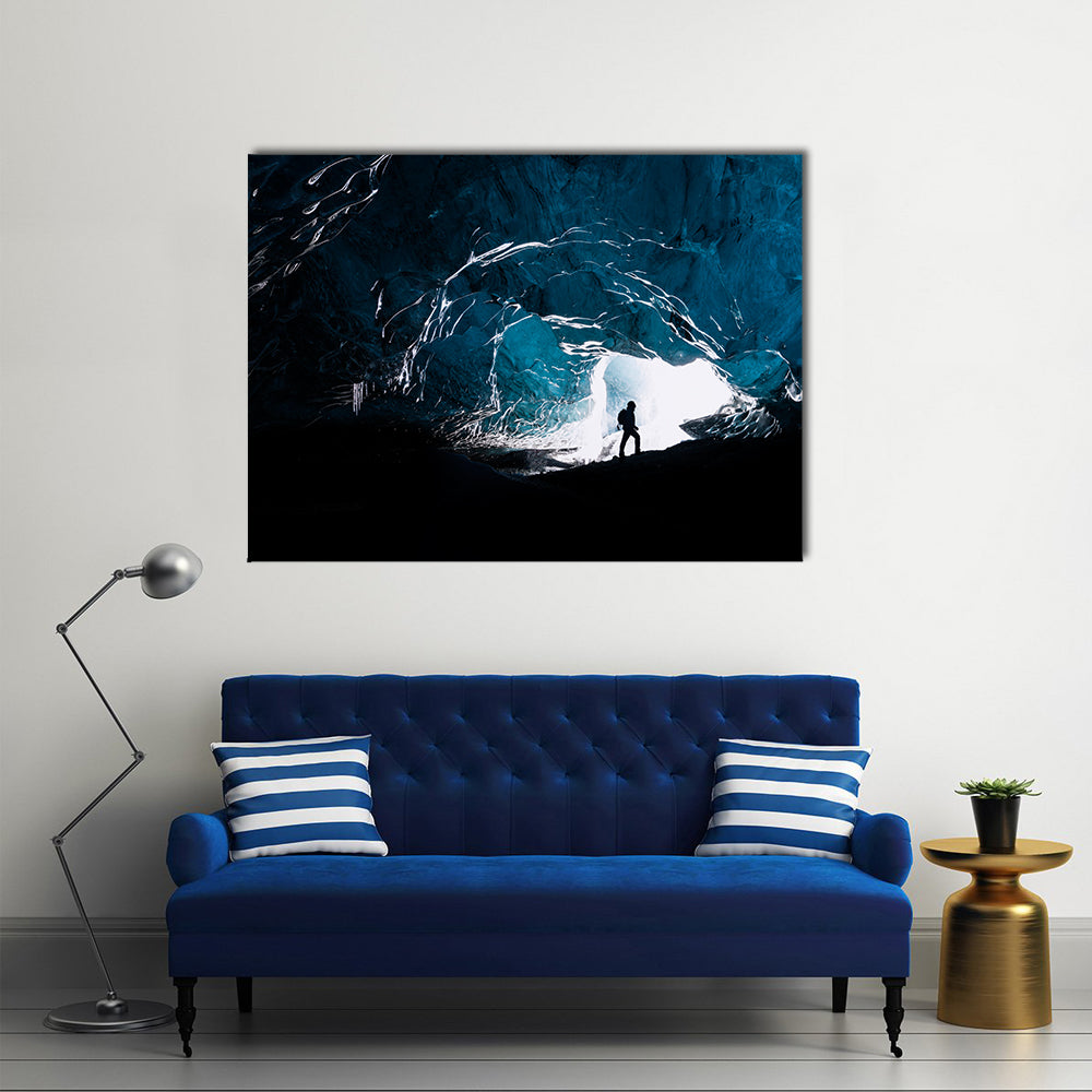 Man exploring an amazing glacial cave in Iceland Multi Panel Canvas Wall Art