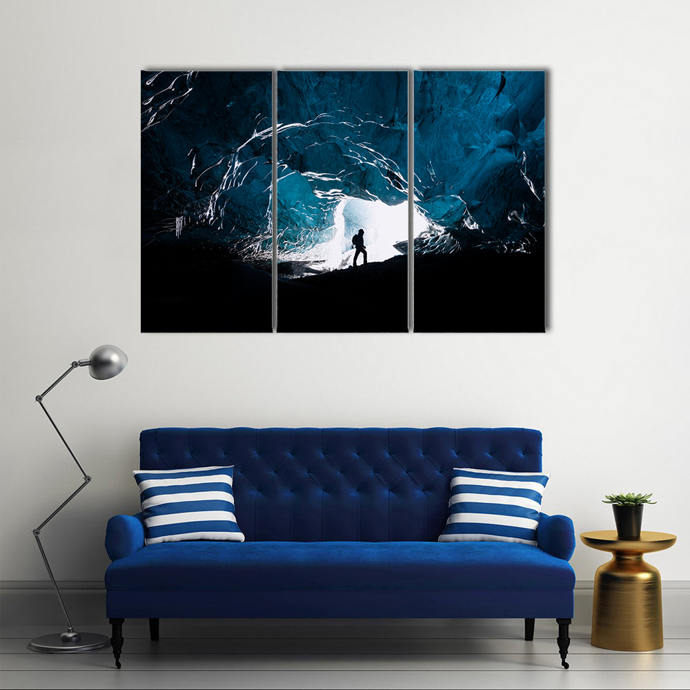Man exploring an amazing glacial cave in Iceland Multi Panel Canvas Wall Art