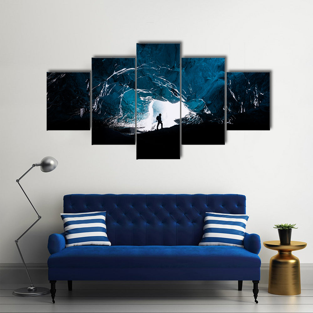 Man exploring an amazing glacial cave in Iceland Multi Panel Canvas Wall Art