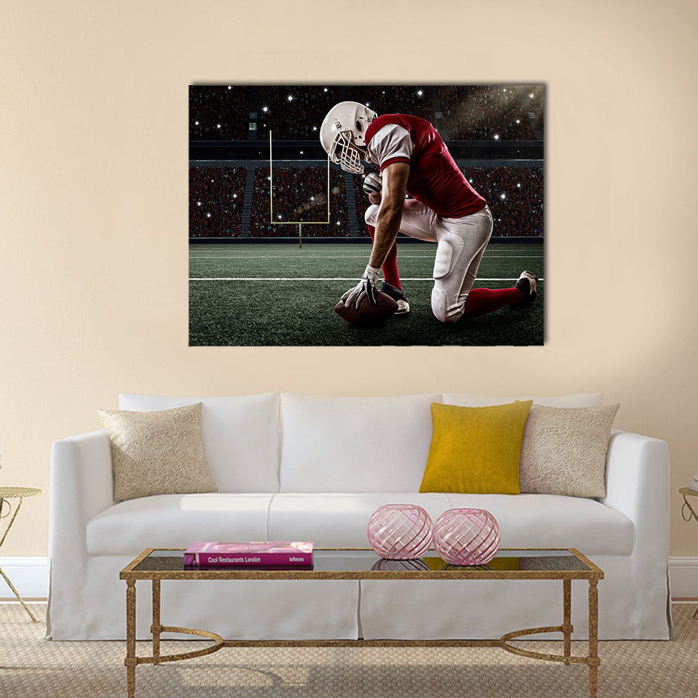 Football Player with a red uniform on his knees, on a Stadium Multi panel canvas wall art
