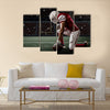 Football Player with a red uniform on his knees, on a Stadium Multi panel canvas wall art