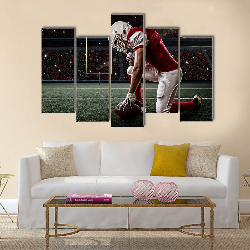 Football Player with a red uniform on his knees, on a Stadium Multi panel canvas wall art