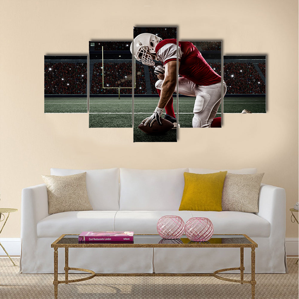 Football Player with a red uniform on his knees, on a Stadium Multi panel canvas wall art
