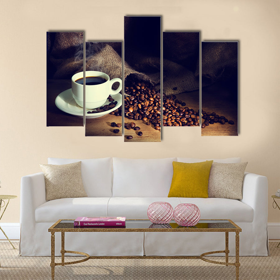 Coffee cup and coffee beans on a wooden table Multi Panel Canvas Wall Art