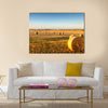 Freshly cropped, farm land hay bales on a sunset Multi panel canvas wall art