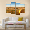 Freshly cropped, farm land hay bales on a sunset Multi panel canvas wall art