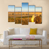 Freshly cropped, farm land hay bales on a sunset Multi panel canvas wall art