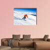 Skier in mask slides fast while skiing from slope Multi panel canvas wall art