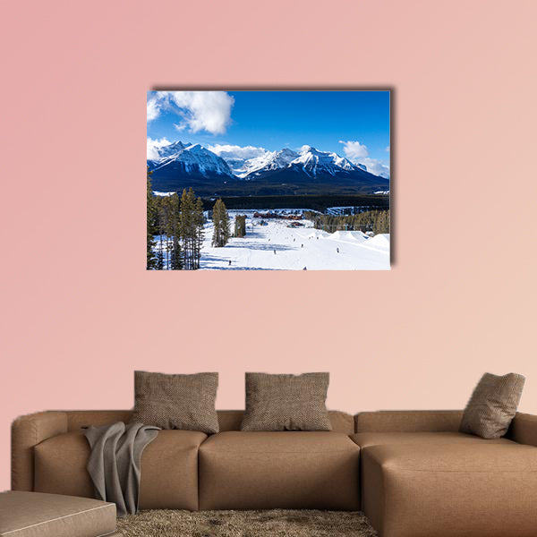 Skiers and snowboarders descend the slopes toward Lake Louise art