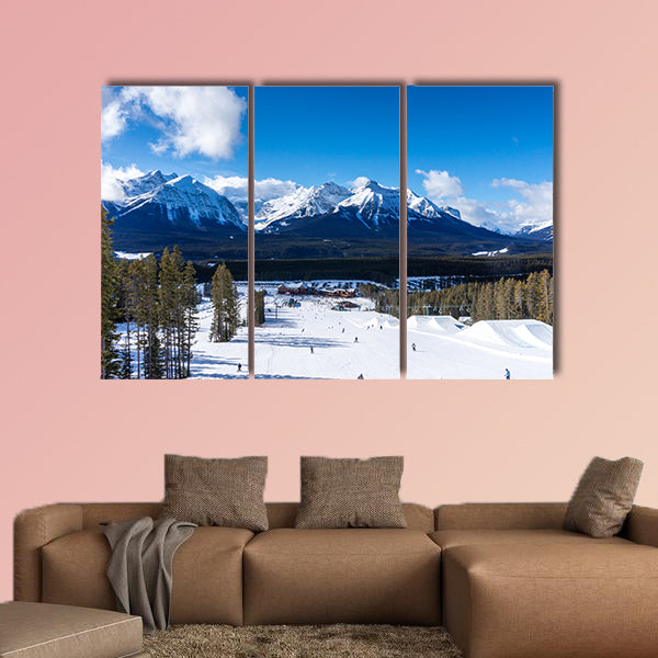 Skiers and snowboarders descend the slopes toward Lake Louise art