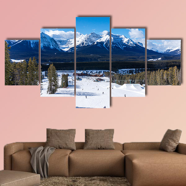 Skiers and snowboarders descend the slopes toward Lake Louise art