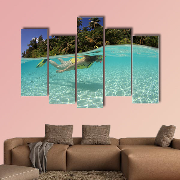 Snorkeler diving in beautiful blue lagoon Multi panel canvas wall art