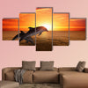 Marine life background - jumping dolphins, beautiful red sunset on sea Multi panel canvas wall art