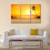 A beautiful sunset over the ocean with a palm tree and wooden jetty foreground Multi panel canvas wall art