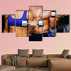 Bodybuilding couple against dark room Multi panel canvas wall art