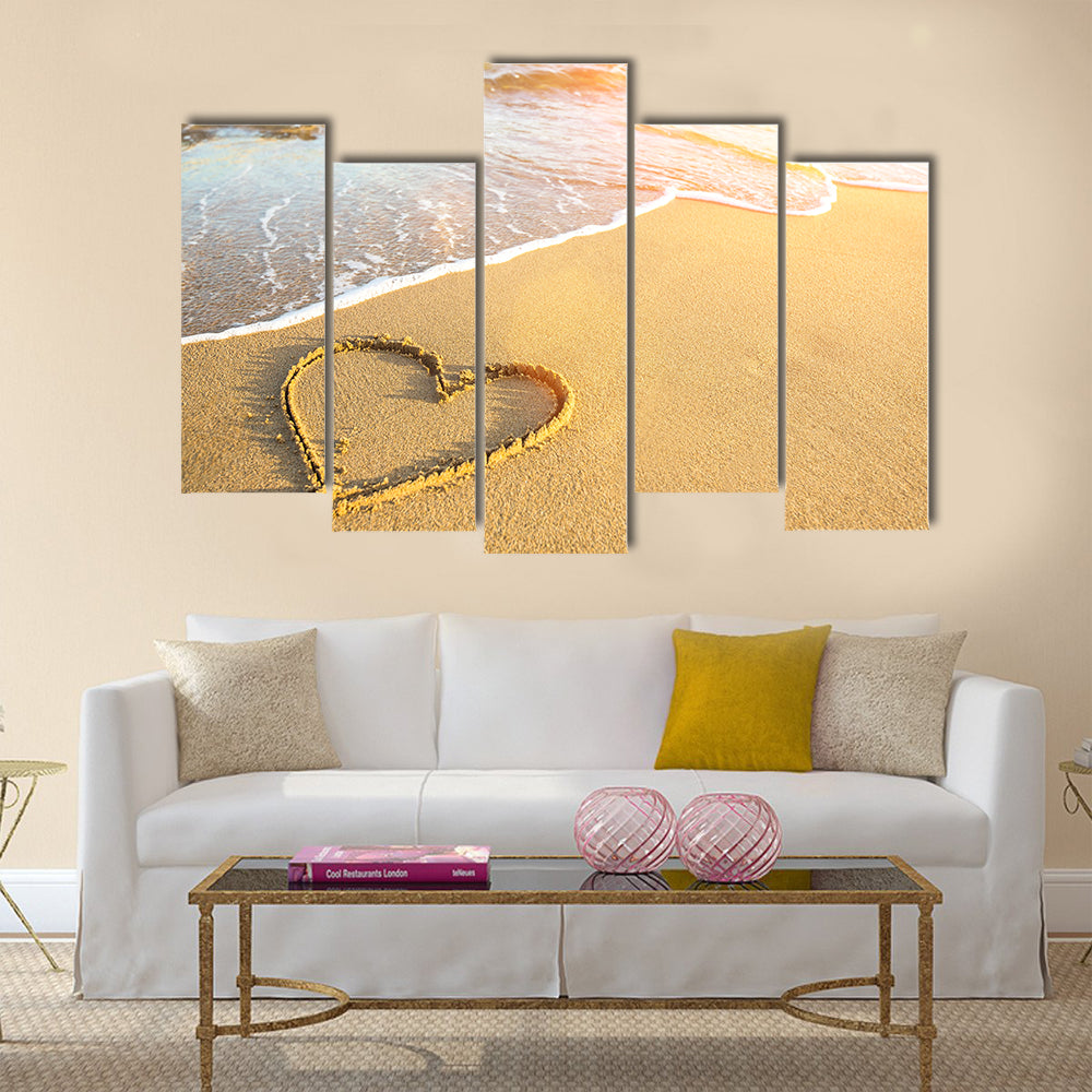 Heart drawn on the sand of a sea beach, soft wave and solar glare Multi panel canvas wall art